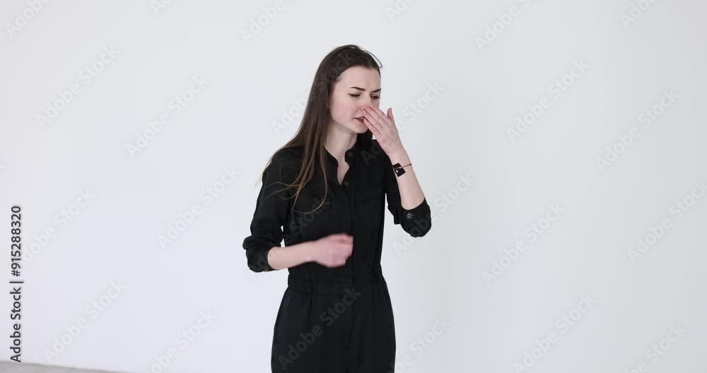 Woman experiences panic attack feeling oxygen deprivation. Young female puts palm on mouth knocking with hand on chest on white background Woman experiences panic attack feeling oxygen deprivation. Young female puts palm on mouth knocking with hand on chest on white background