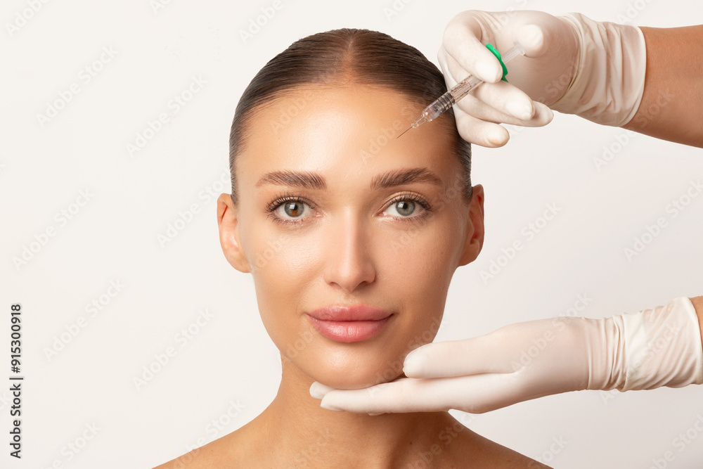 Ταπετσαρία Young European woman getting beauty cosmetic injection in forehead at clinic, white studio background