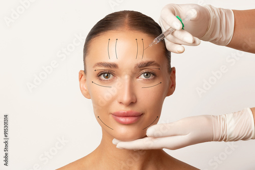 Obraz na plátně Beautiful lady face with arrows, botulinum toxin injections in woman's forehead