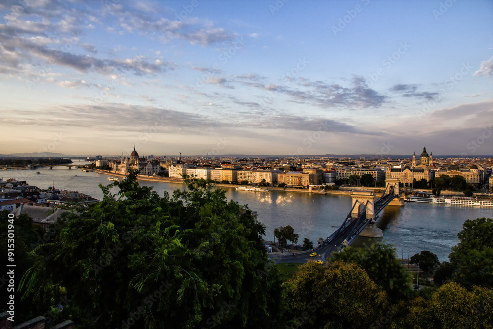 Obraz premium Beautiful view from above of Budapest capital of Hungary in Europe. The Parliament above the Danube river flowing crossed by ships. The bridges with cars trams and bicycles. Travel concept