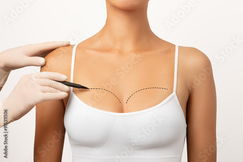 Foto Plastic surgeon marking woman's breast, drawing lines on chest, white studio bac