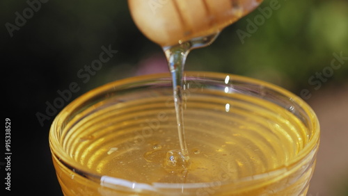 Wooden honey stick. Dripping honey. Extraction honey with a dipper. Honey drizzler photo