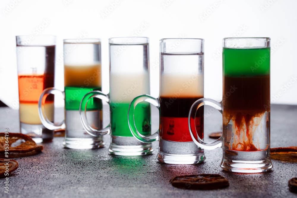 Short alcoholic drinks for a bar cocktail card. Party concept for girls. Multicolored cocktail tubes. Row of glasses with fruit mojito cocktails. Alcohol games for night clubs. Short alcoholic drinks for a bar cocktail card. Party concept for girls. Multicolored cocktail tubes. Row of glasses with fruit mojito cocktails. Alcohol games for night clubs.