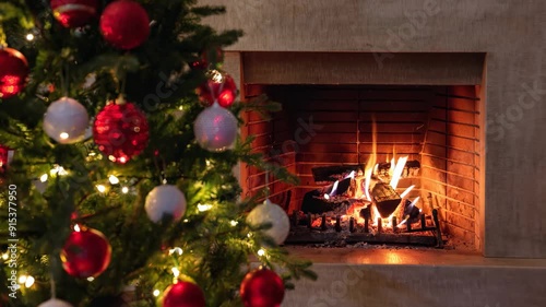 Christmas tree close up on burning fireplace background