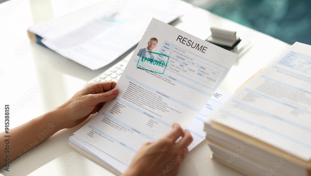 Hands holding resume of man for employment with stamp approved closeup. Work searches concept Hands holding resume of man for employment with stamp approved closeup. Work searches concept