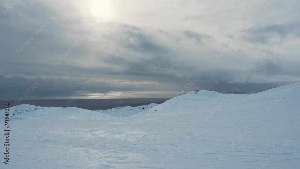 Tourist riding snowmobiles on snowy glacier mountain summit in winter Tourist riding snowmobiles on snowy glacier mountain summit in winter