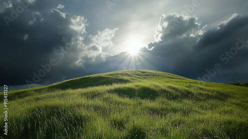 photo of a grassy hilltop with the sun poking through the clouds, sunny day