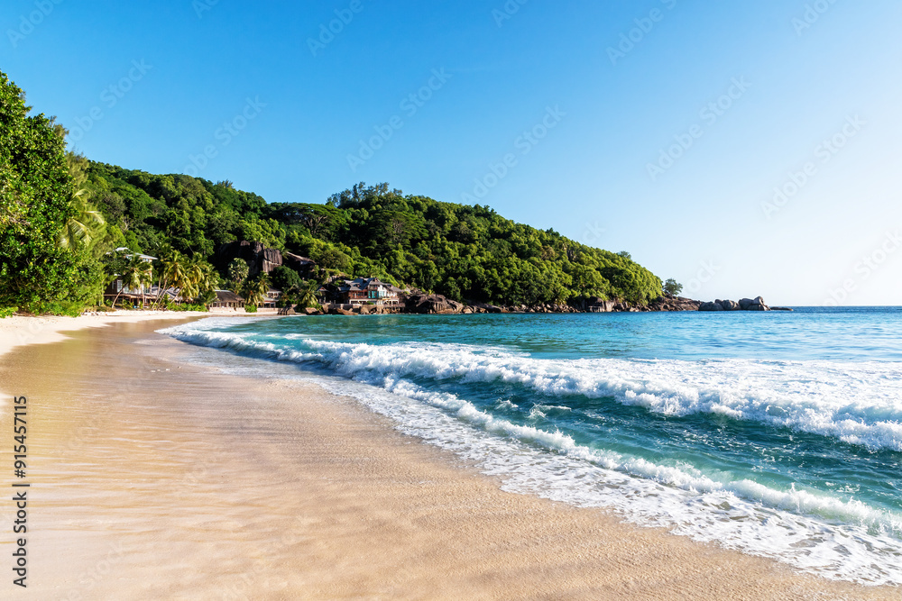 Panoramic view of tropical beach with white sand, clear turquoise water. The waves are crashing on the shore, creating a sense of tranquility Panoramic view of tropical beach with white sand, clear turquoise water. The waves are crashing on the shore, creating a sense of tranquility