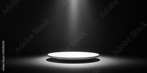 Empty round stage illuminated by white spotlight on dark background