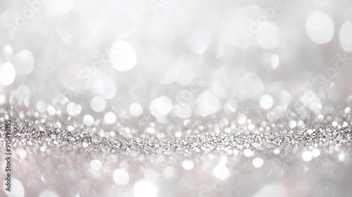 Soft silver glitter sparkles on a pastel white background, de-focused for a gentle, luxurious feel