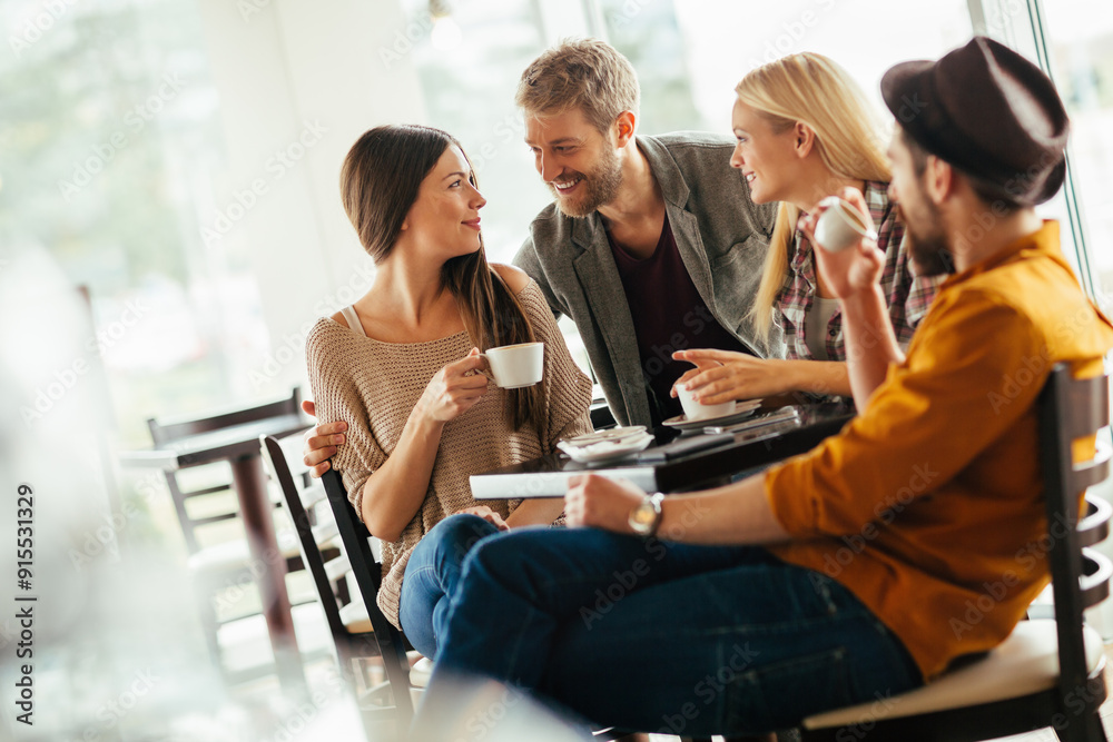 Diverse young friends drinking coffee in busy cafe Diverse young friends drinking coffee in busy cafe