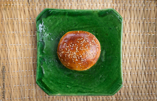 Moroccan Krachel bun, sweet bread with Aniseed (anise) Sesame Seeds, brioche bun, on a traditional handmade green plate, top view, aerial shot, flat lay, Marrakech, Marrkesh Morocco, North Africa photo