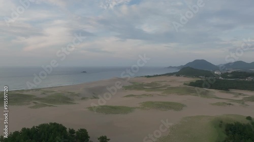 Flying over Empty Sand Dunes on Peaceful Coast at Sunset