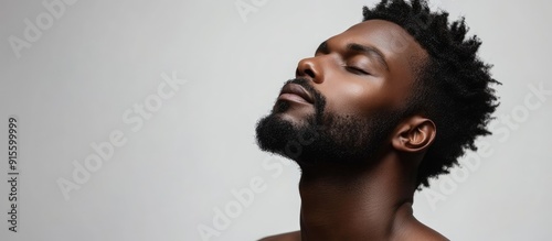 An appealing Afro American man is posing in a studio against an isolated background. with copy space image. Place for adding text or design