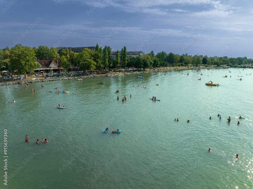 Beach in Lake Balaton. People bathing in the water of lake in hot summertime. There are many popular summer resorts around the lake Balaton in Hungary.