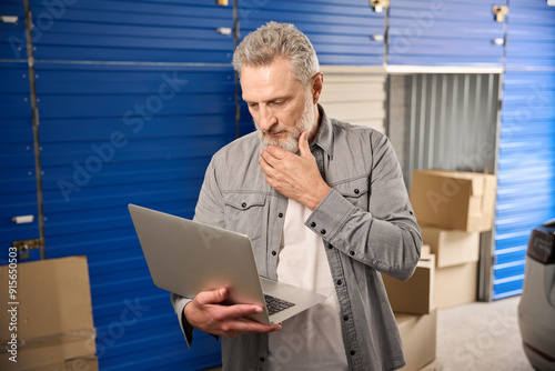 Male working on computer in storage unit