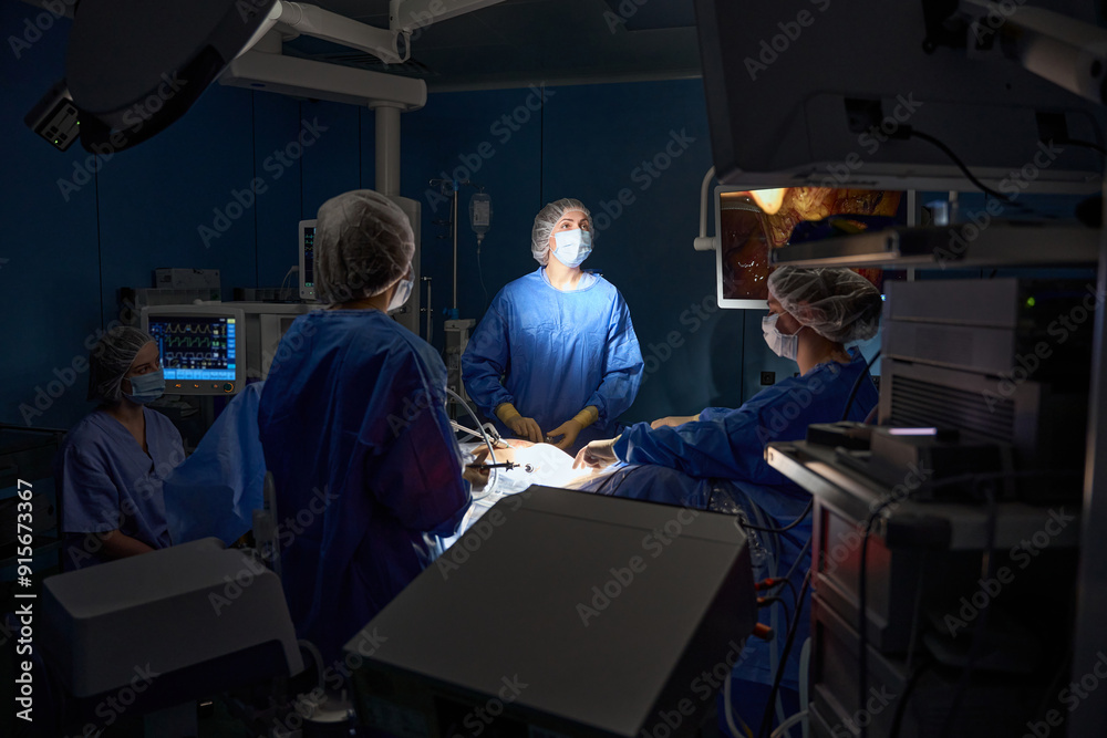 Obraz premium Doctors in protective masks doing operation in the operating room in hospital
