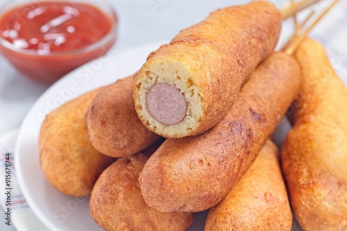 Corn dogs on white plate, served with ketchup, horizontal closeup