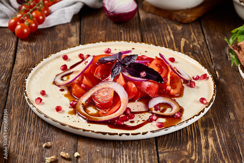 Fresh Tomato and Red Onion Salad with Narsharab Sauce on Rustic Wooden Table photo