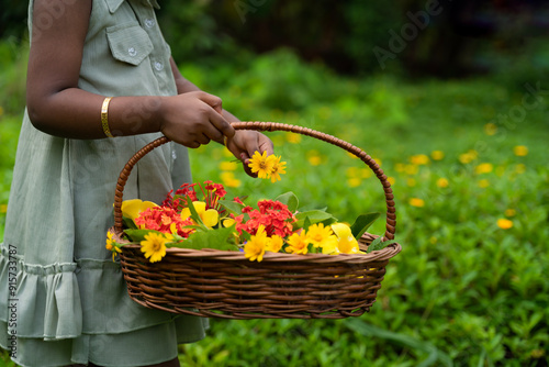 Young girl Holding Basket Full Of Flowers for Onam decoration, Onam festival celebration concept image