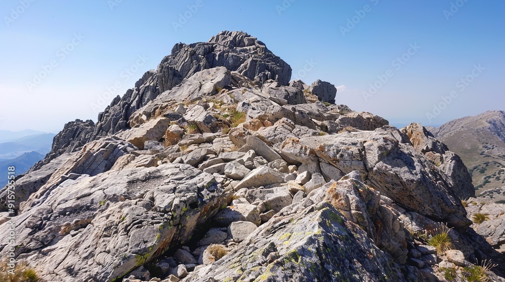 The rocky summit of a mountain with a clear, blue sky overhead. The rocky summit of a mountain with a clear, blue sky overhead.