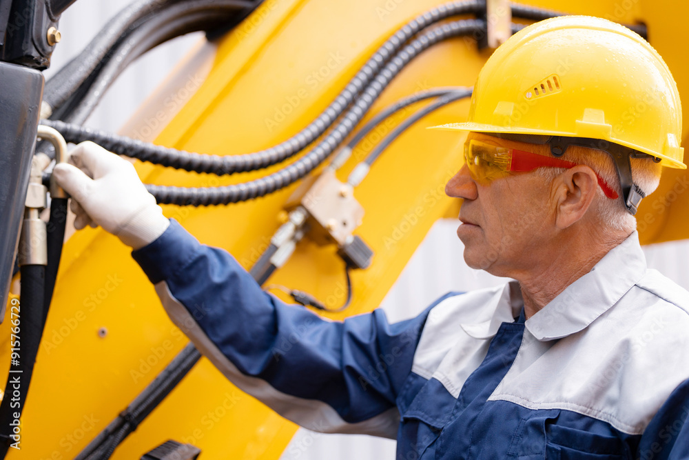 Hydraulic engineer doing safety check on new installation hoses of modern drilling industrial machine Hydraulic engineer doing safety check on new installation hoses of modern drilling industrial machine