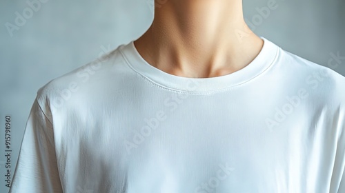 A close-up of a person wearing a plain white t-shirt, highlighting the simplicity and versatility of this wardrobe staple