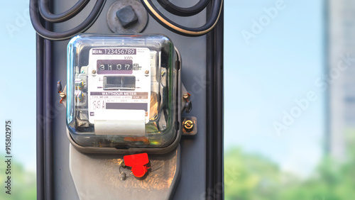 Electricity meter on electric power pole with cable line and blurred outdoor background, close up with copy space, The meter number is a suppose number. photo