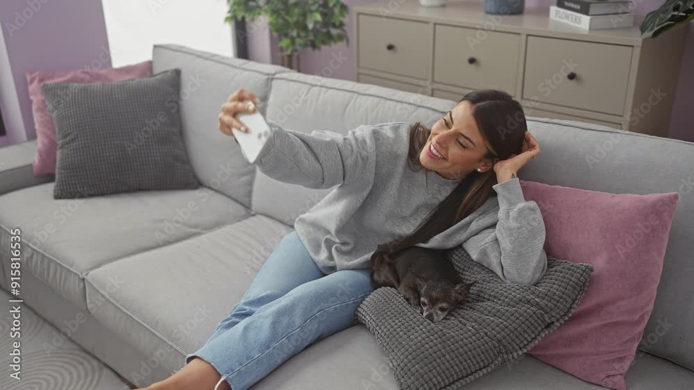 A woman lounges with her chihuahua on a modern sofa at home, taking selfies and texting indoors. A woman lounges with her chihuahua on a modern sofa at home, taking selfies and texting indoors.