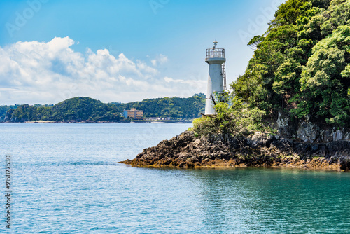 Dramatic rock formations on the coast of Pacific Ocean in Nachikatsuura, Wakayama, Japan, part of the Yoshino-Kumano National Park and Nanki Kumano geopark. Ugui Komazaki Lighthouse photo