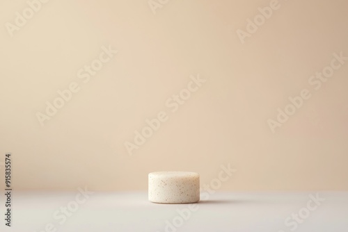 A Speckled White Cylinder on a Beige Background
