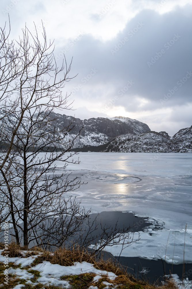 A tranquil winter scene with frozen sea bay, snowy mountains and ice formations, Lofoten Island, Norway A tranquil winter scene with frozen sea bay, snowy mountains and ice formations, Lofoten Island, Norway