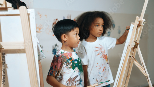 Fotografie Happy creative african girl painted or draw canvas together with asian boy