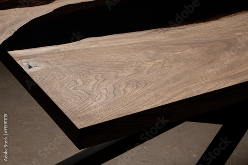Expensive vintage furniture. The table is covered with epoxy resin and varnished. Luxury quality wood processing. Wooden table on a dark background. Black river made of epoxy resin.