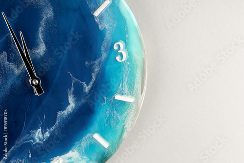 Round wall clock with ocean shore pattern. Vacation time concept. Time for rest and lunch. Luxurious epoxy resin accessories for the living room or lounge area. The concept of a minute of the Earth. photo