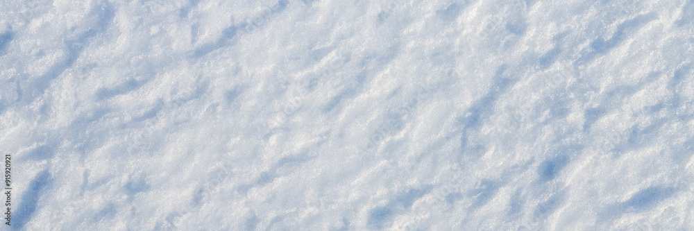 Natural snow texture. The surface of the snow crust. Snowy ground. Winter background with snow patterns. Perfect for Christmas and New Year design. Closeup top view.