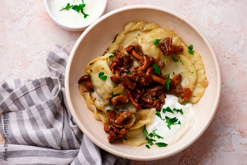 Polish dumplings with fried chanterelles and sour cream on a plate..style hugge.