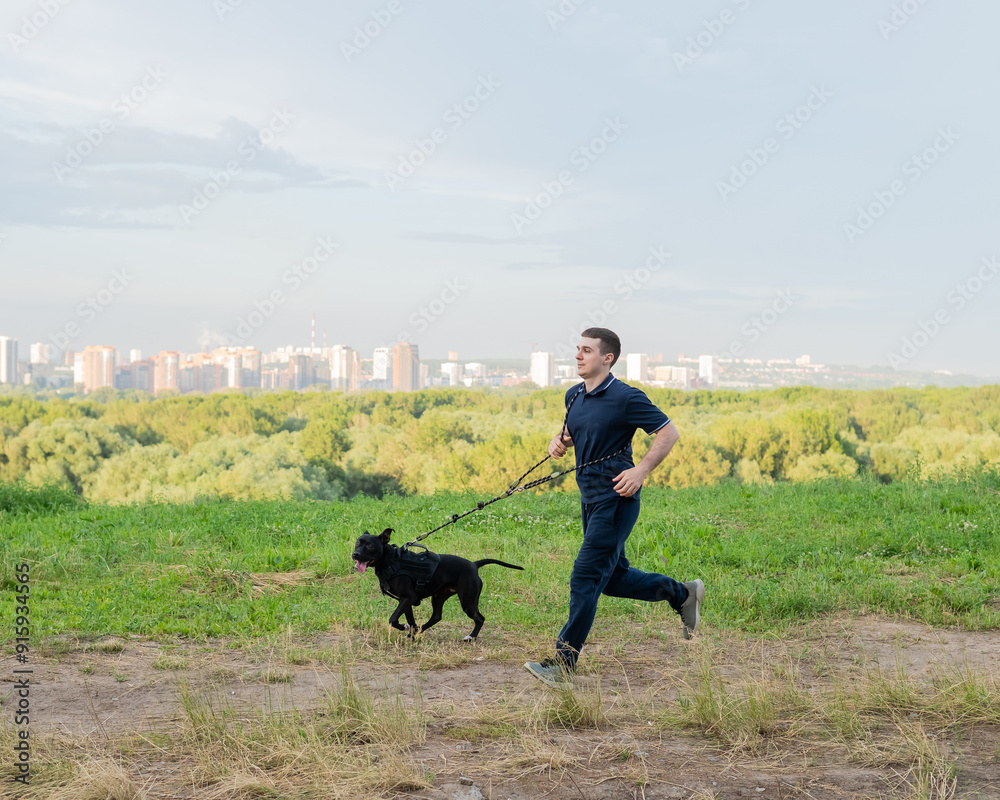 Man running with pit bull terrier outdoors. Man running with pit bull terrier outdoors.