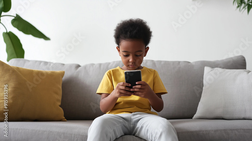 Cute Child Sitting on Sofa Using Smartphone for Technology and Modern Childhood Photography Themes photo