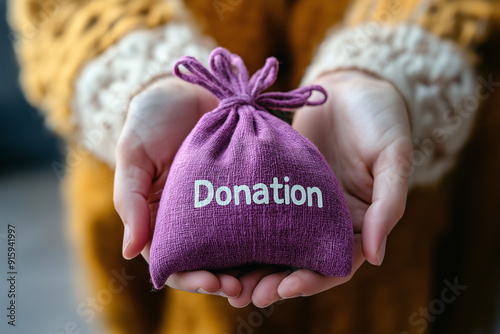 Hands Presenting Purple Donation Bag for Charity and Generosity Themes in Hands and Donation Photography photo