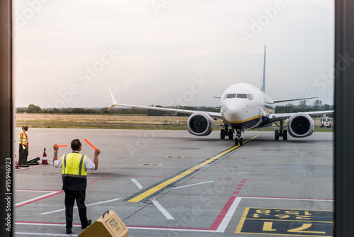 Airport Worker Directing Airplane for Parking After Landing. photo