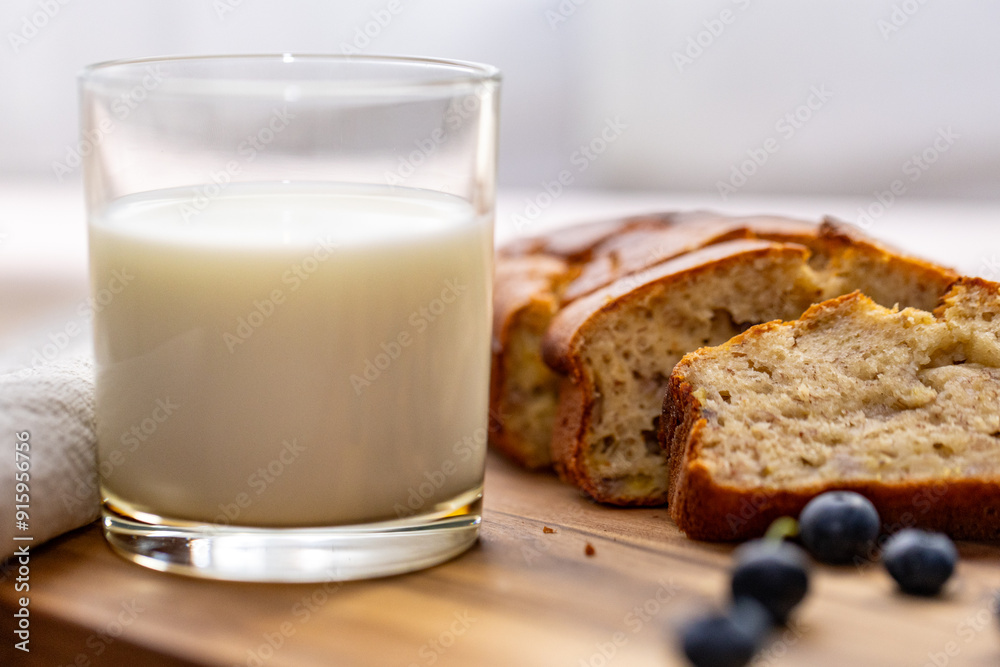 glass of milk and sweet homemade banana bread with crispy crust on a wooden board, dessert glass of milk and sweet homemade banana bread with crispy crust on a wooden board, dessert