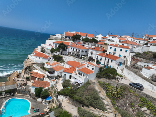 A picturesque village perched on a cliff overlooking the ocean The white houses with red roofs are charming