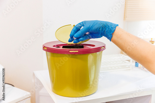 Medical garbage can. Container for hazardous waste in hospital. Throw medical waste and used syringes into the trash can. The nurse throw away used syringe and bottle.
