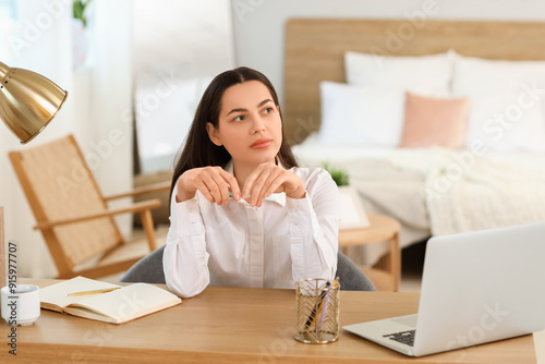 Thoughtful young woman sitt...
