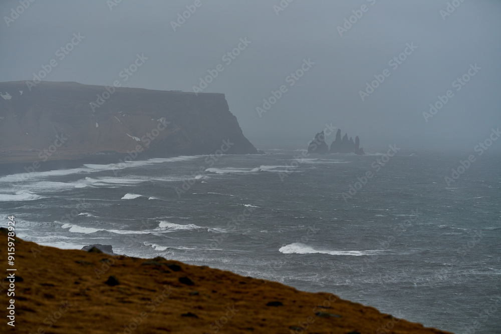 Storm approaching icelandic coast with black sand beach and sea stacks Storm approaching icelandic coast with black sand beach and sea stacks