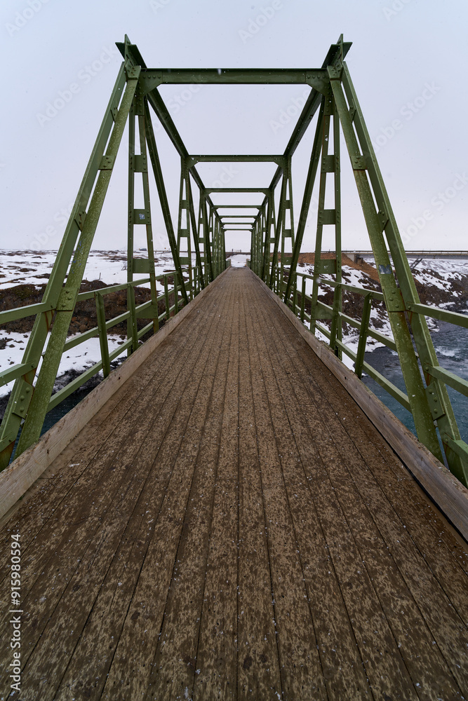 Old green metal bridge crossing a river in winter Old green metal bridge crossing a river in winter
