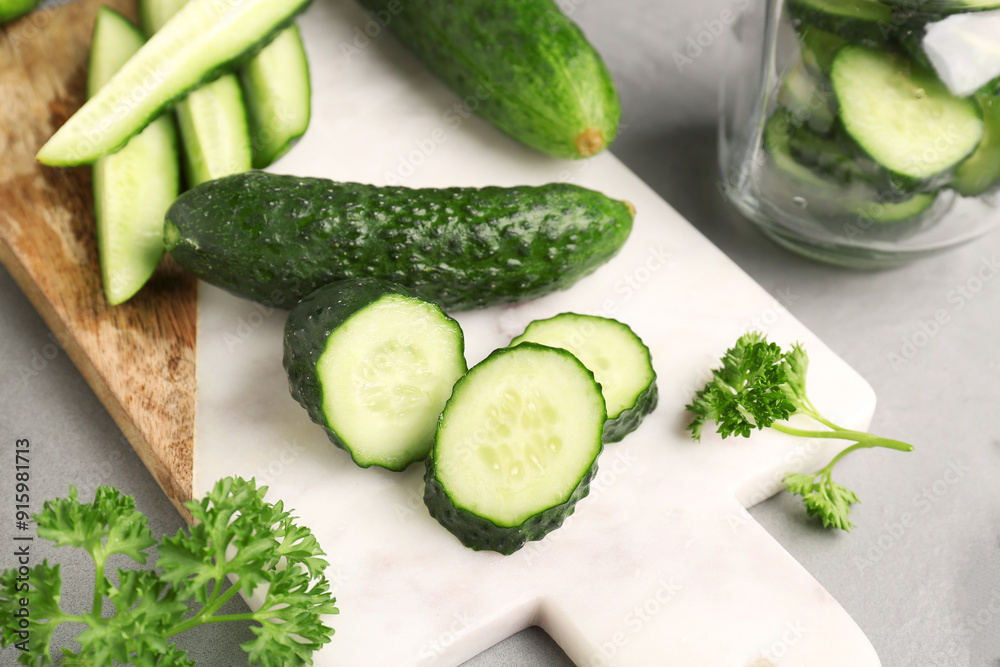 Board with fresh cut cucumbers on table Board with fresh cut cucumbers on table