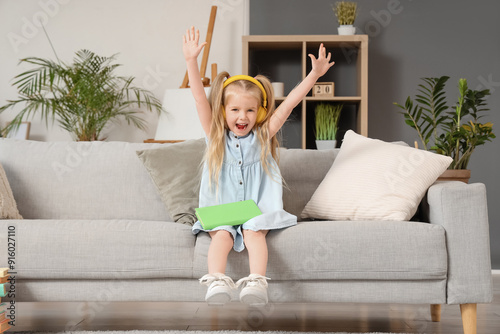 Happy little girl in headph...