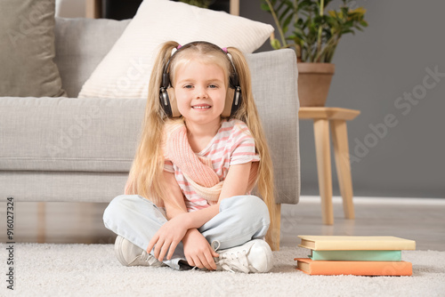 Cute little girl in headpho...